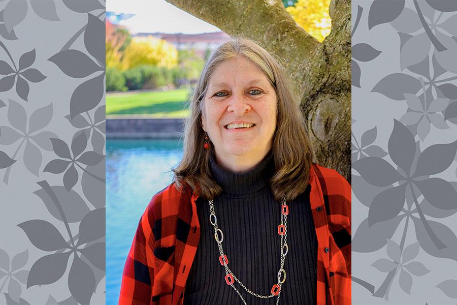 Woman in red and black with pond and beautiful campus scenery in background
